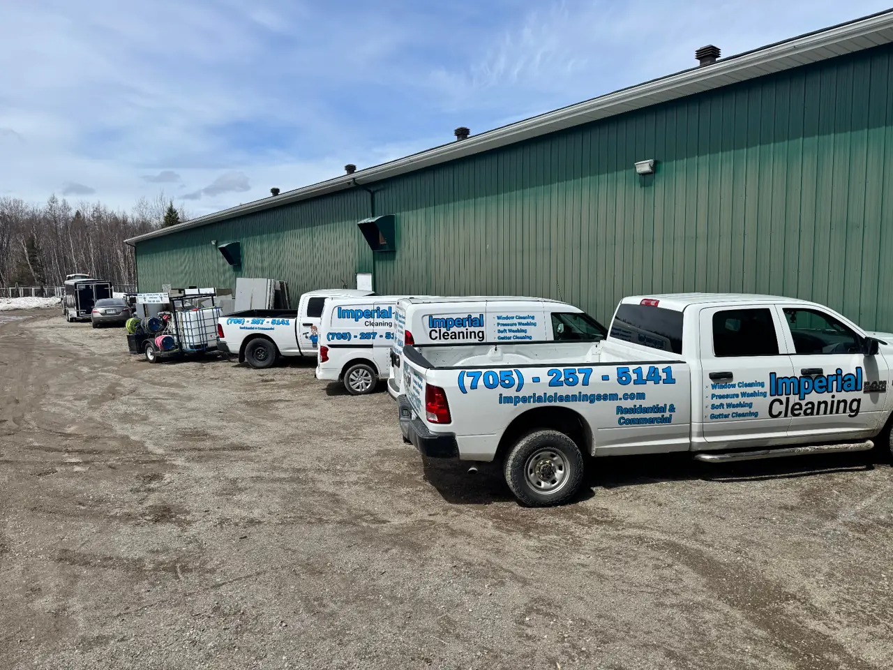 Imperial Cleaning branded truck and van fleet parked at the shop in Sault Ste. Marie, Ontario — window cleaning, pressure washing, soft washing and gutter cleaning